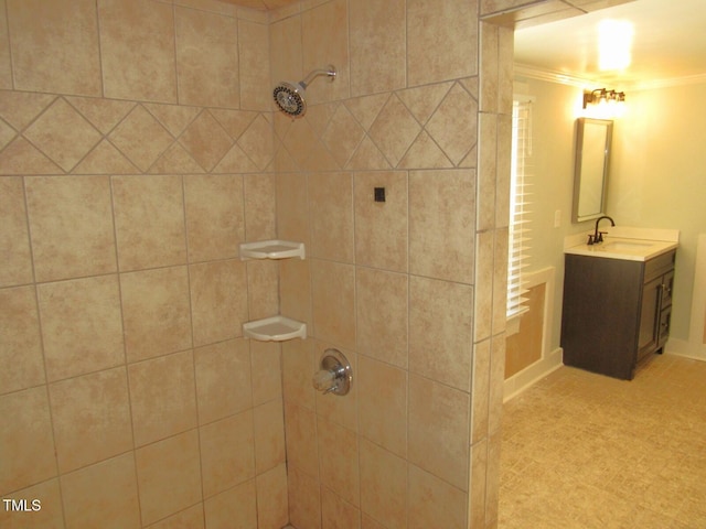 bathroom with vanity, crown molding, and a tile shower