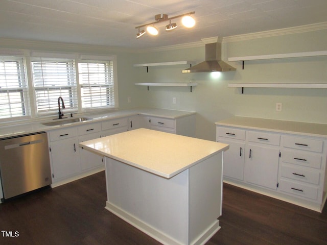 kitchen with sink, white cabinets, a kitchen island, stainless steel dishwasher, and exhaust hood