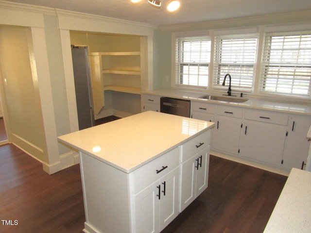 kitchen featuring dishwasher, white cabinetry, sink, a center island, and crown molding