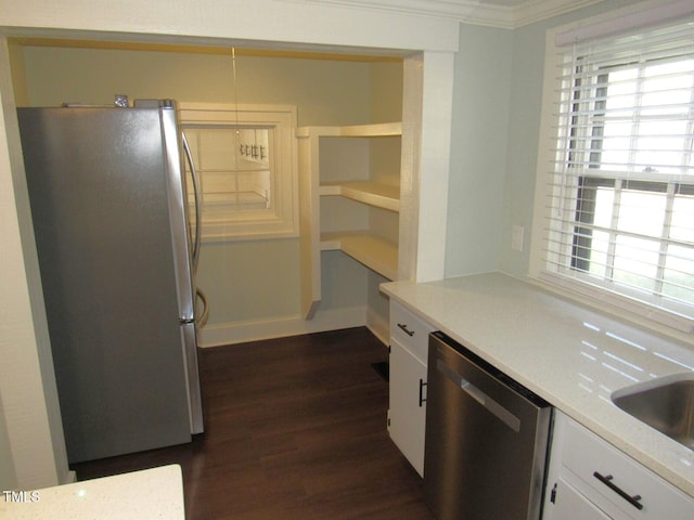 kitchen with appliances with stainless steel finishes, white cabinetry, sink, dark hardwood / wood-style flooring, and crown molding