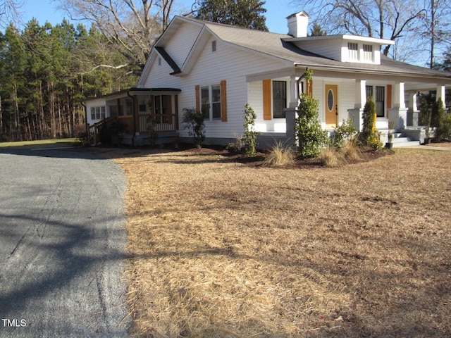 view of side of home featuring covered porch