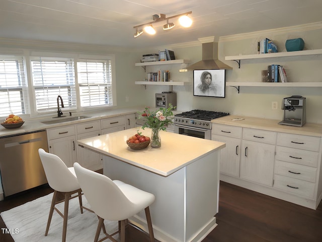 kitchen featuring sink, a breakfast bar area, appliances with stainless steel finishes, white cabinets, and a kitchen island