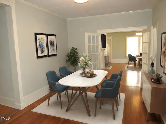 dining space featuring ornamental molding and light wood-type flooring