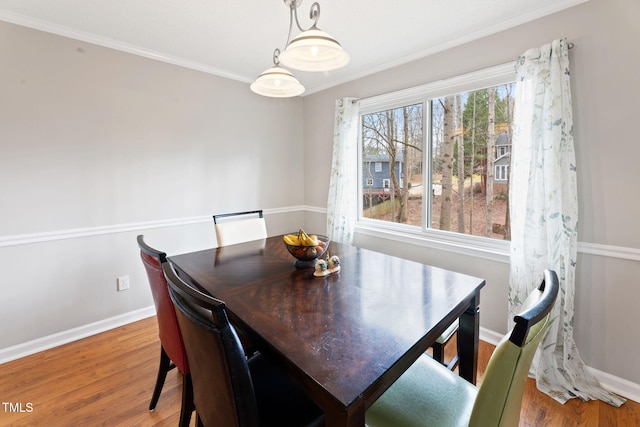 dining space featuring ornamental molding and wood-type flooring