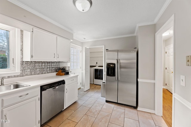 kitchen featuring appliances with stainless steel finishes, sink, backsplash, white cabinets, and ornamental molding