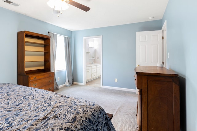 bedroom with ceiling fan, light carpet, and ensuite bathroom