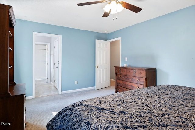 carpeted bedroom with ensuite bath and ceiling fan