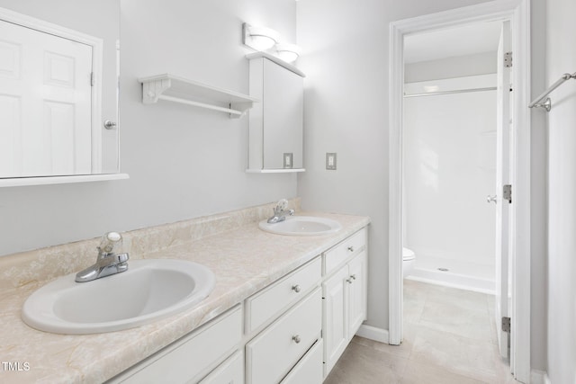 bathroom with vanity, toilet, and a shower