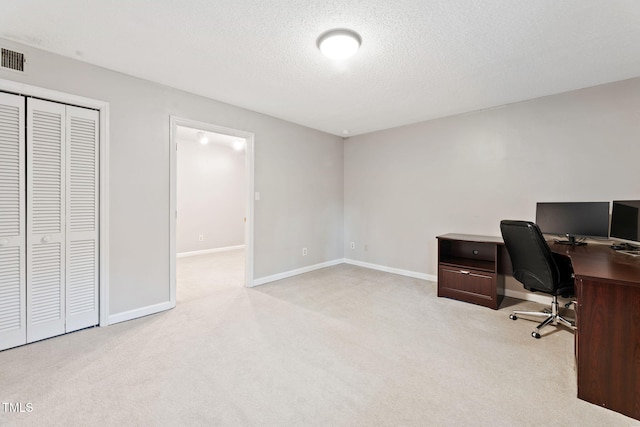 carpeted office space featuring a textured ceiling