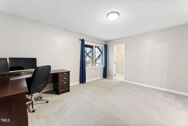 carpeted home office featuring a textured ceiling