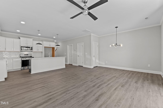 608 Marshskip Way, Rolesville, NC 27587 - unfurnished living room featuring ornamental molding, a sink, a chandelier, ceiling fan, and baseboards