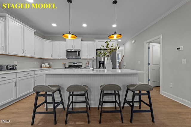 608 Marshskip Way, Rolesville, NC 27587 - kitchen featuring appliances with stainless steel finishes, a breakfast bar area, white cabinets, ornamental molding, and recessed lighting