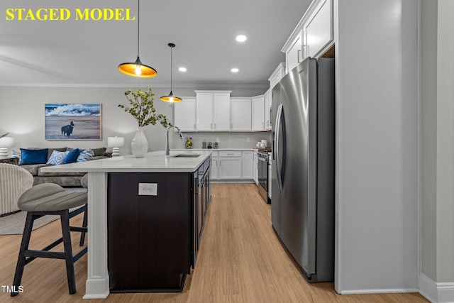 608 Marshskip Way, Rolesville, NC 27587 - kitchen with stainless steel appliances, a sink, open floor plan, light countertops, and white cabinetry