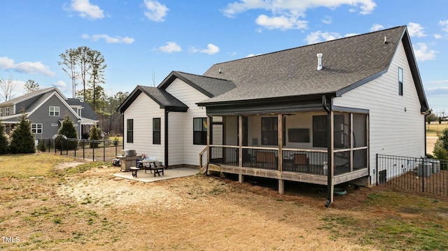 back of house featuring a sunroom, a yard, and a patio area