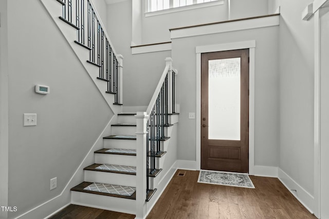 entrance foyer with dark wood-type flooring and a healthy amount of sunlight