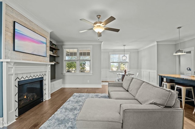 living room with wood-type flooring, a fireplace, and crown molding