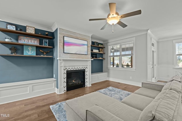 living room featuring a large fireplace, ornamental molding, dark hardwood / wood-style floors, and built in features