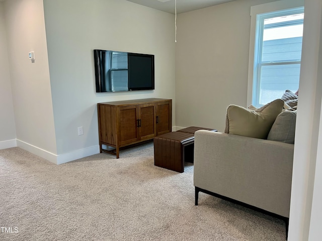living area with light colored carpet and baseboards