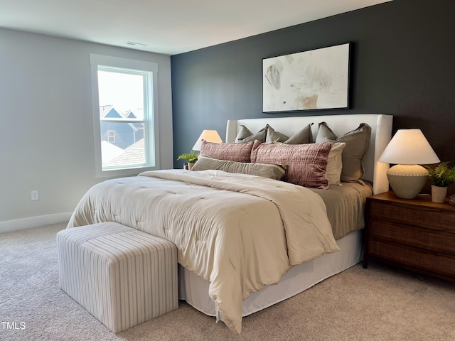 bedroom featuring light colored carpet, visible vents, and baseboards