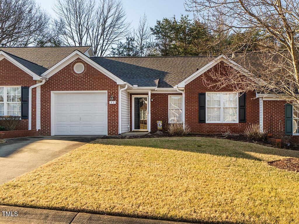 single story home featuring a garage and a front yard