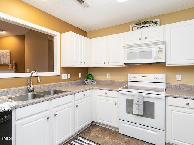 kitchen with white cabinetry, white appliances, dark tile patterned flooring, and sink