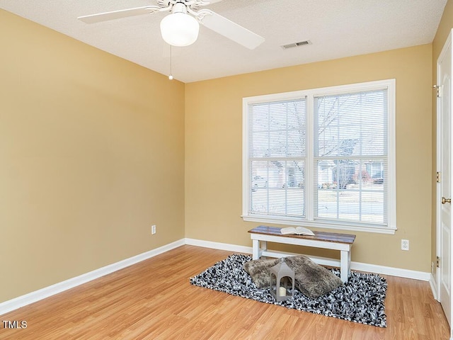 interior space with wood-type flooring and ceiling fan