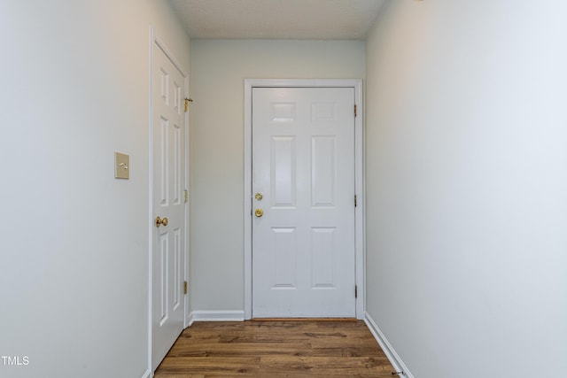 doorway featuring a textured ceiling and dark hardwood / wood-style flooring