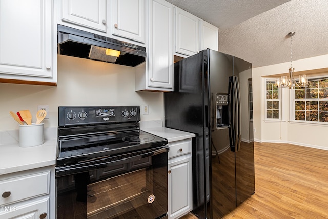 kitchen with decorative light fixtures, white cabinetry, light hardwood / wood-style floors, black appliances, and a textured ceiling