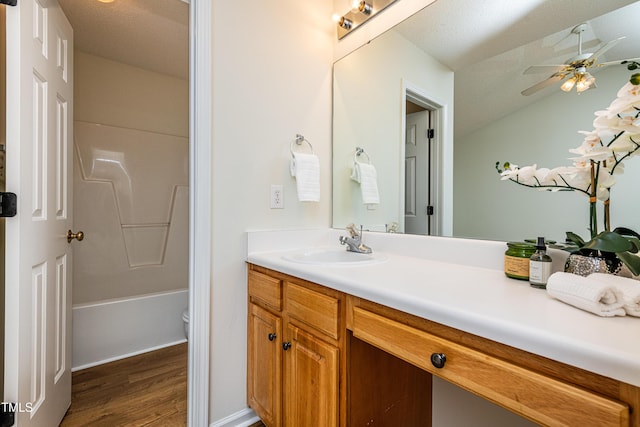 full bathroom with hardwood / wood-style flooring, vanity, a textured ceiling, and toilet