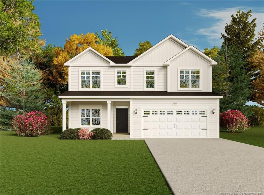 view of front of property with a garage and a front lawn