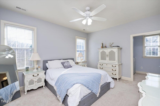 carpeted bedroom featuring multiple windows and ceiling fan