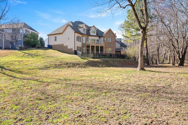 back of house featuring a balcony and a lawn