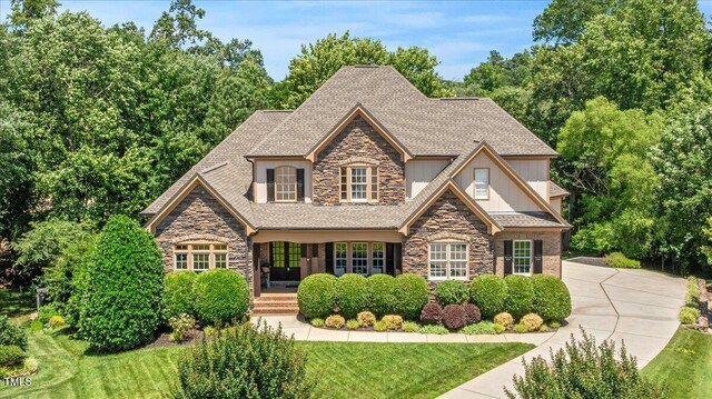 2933 Elmfield St, Raleigh, NC 27614 - view of front of home with stone siding, board and batten siding, and a front lawn