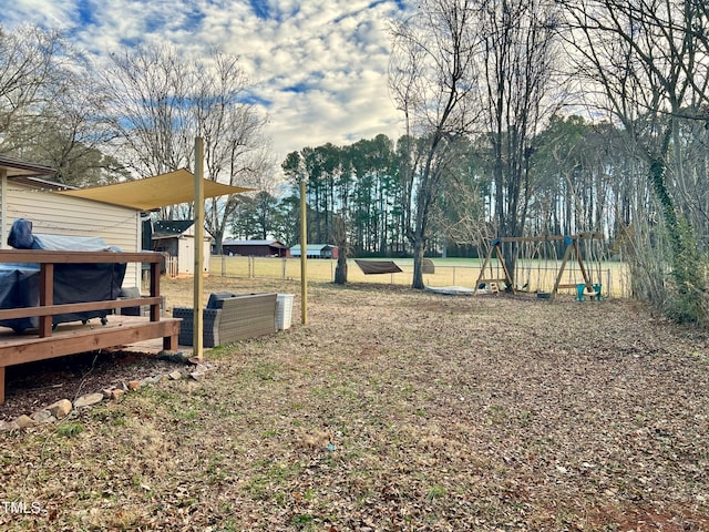 view of yard featuring a playground and a deck