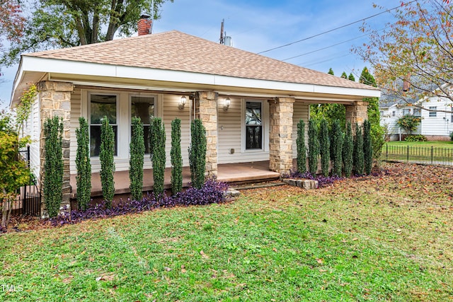 view of front of house with a front yard and covered porch