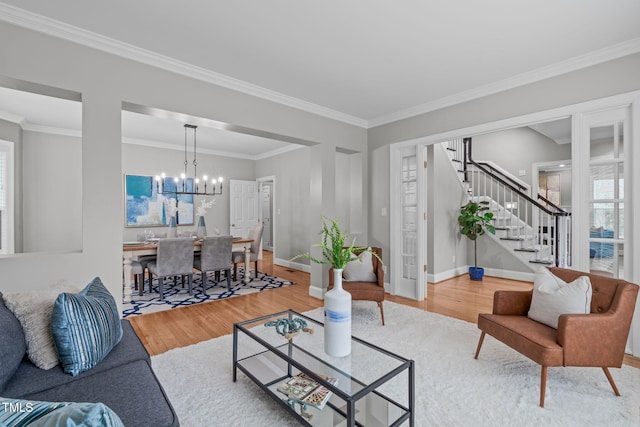 living room featuring a notable chandelier, wood-type flooring, and ornamental molding