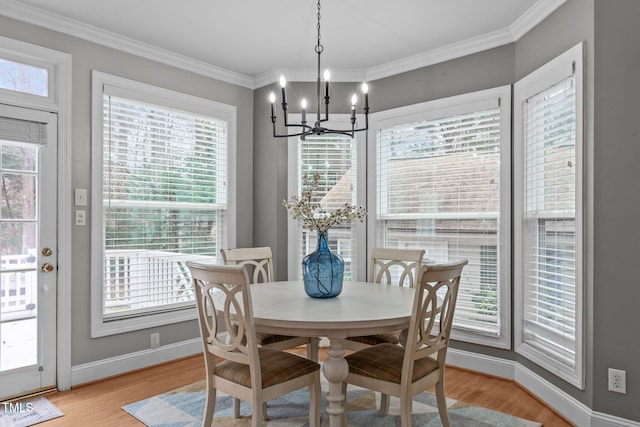 dining space with ornamental molding, an inviting chandelier, and light wood-type flooring