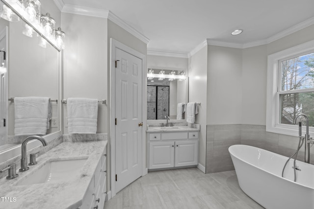 bathroom with crown molding, vanity, and a bathing tub