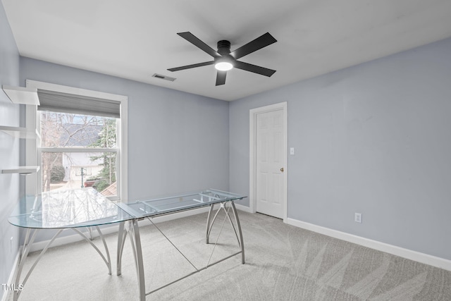 unfurnished office with ceiling fan and light carpet