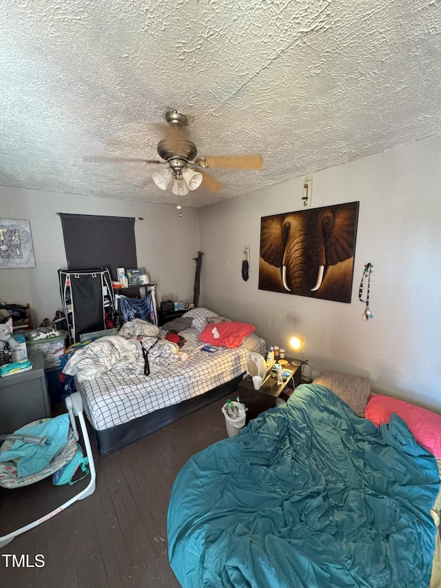 bedroom featuring ceiling fan, hardwood / wood-style flooring, and a textured ceiling