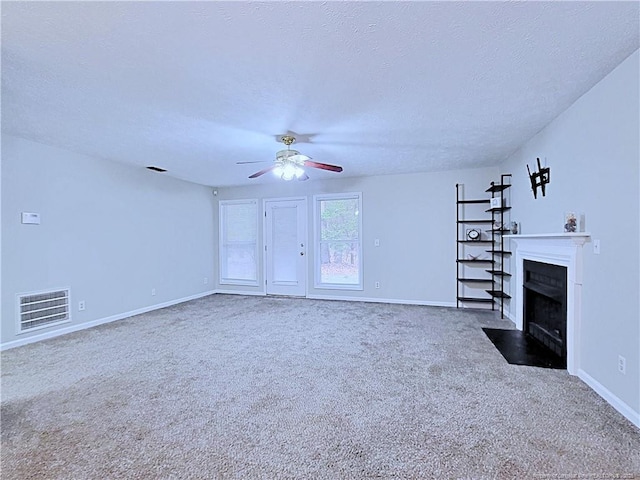 unfurnished living room featuring ceiling fan, carpet flooring, and a textured ceiling