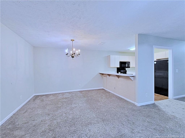 kitchen featuring black appliances, white cabinets, hanging light fixtures, kitchen peninsula, and light carpet