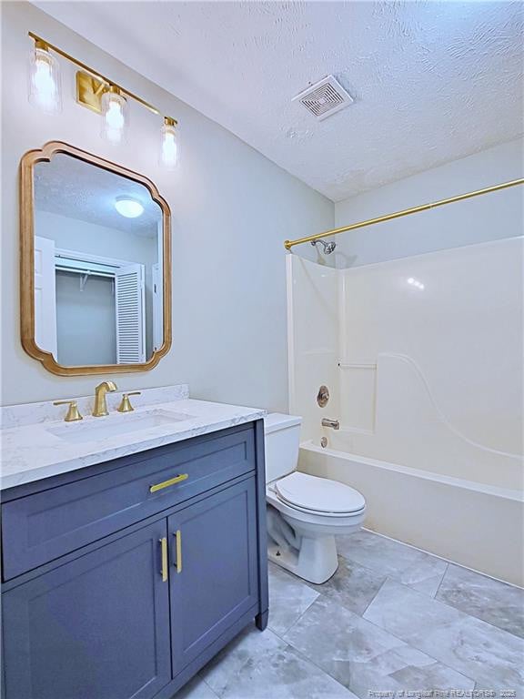 full bathroom featuring washtub / shower combination, vanity, toilet, and a textured ceiling