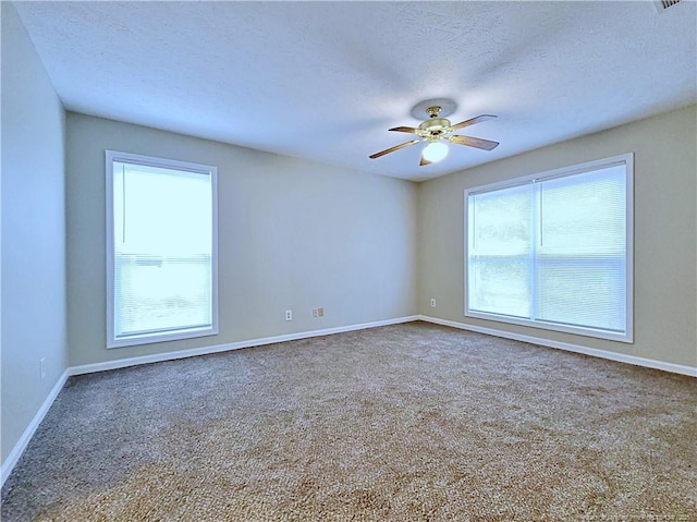 carpeted spare room featuring a textured ceiling and ceiling fan