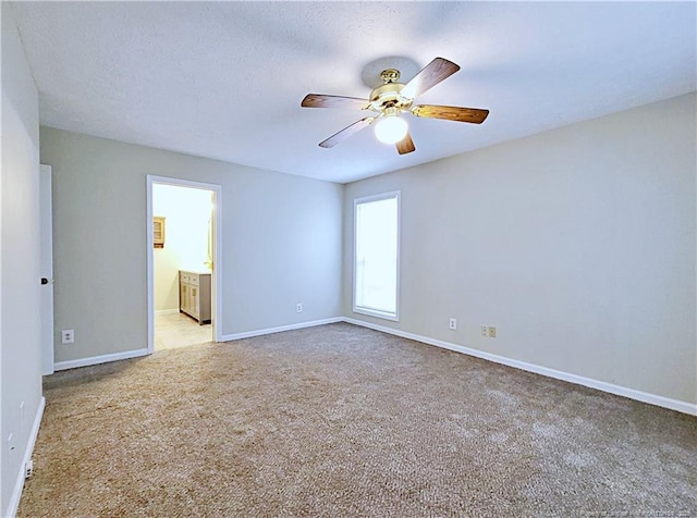 carpeted spare room with ceiling fan