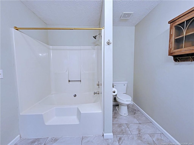 bathroom with shower / bathtub combination, toilet, tile patterned flooring, and a textured ceiling