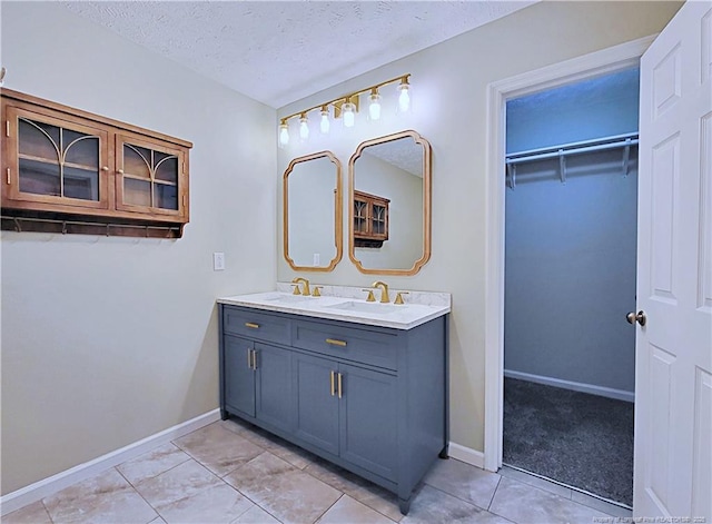 bathroom featuring tile patterned floors, a textured ceiling, and vanity