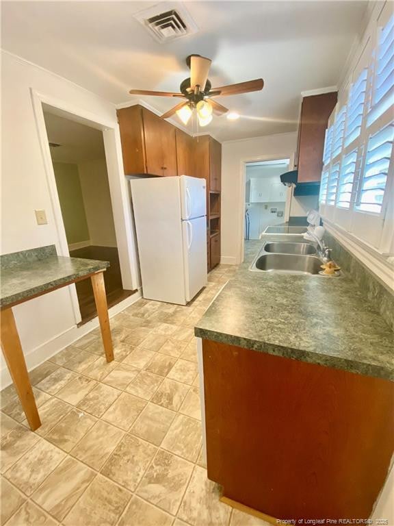 kitchen featuring sink, ceiling fan, and white fridge