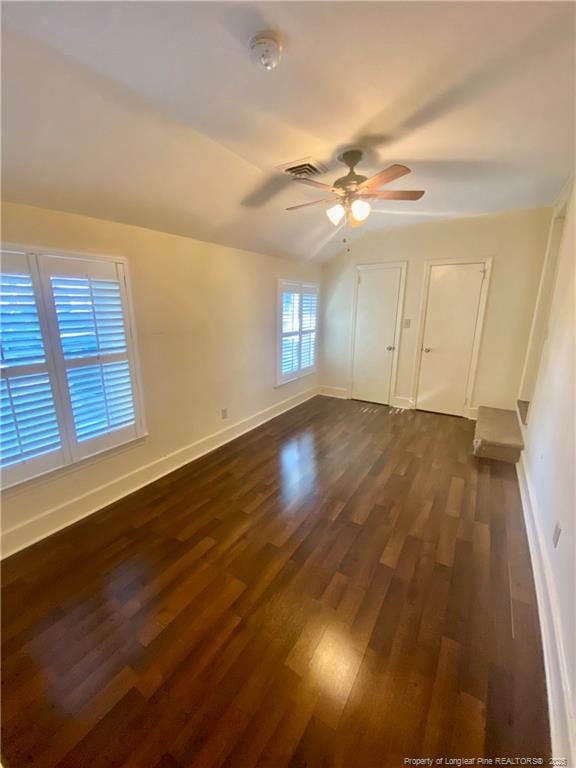 unfurnished room with dark hardwood / wood-style flooring, lofted ceiling, and ceiling fan