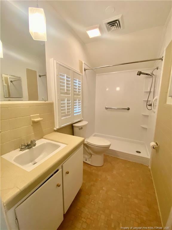 bathroom with tasteful backsplash, a shower, vanity, and toilet